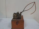 a small wooden box with a metal object on top of it
