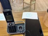a cell phone sitting on top of a desk next to a laptop