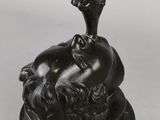 an antique bronze statue of a woman holding a bird on top of a man ' s head