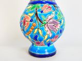 un vase bleu orné d'un motif floral