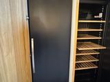 a black refrigerator and a black refrigerator freezer in a room