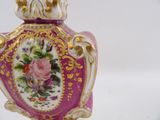 a purple vase with a gold trim and a pink flower on it
