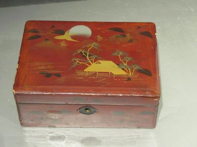 a red box with a painting on it on a table