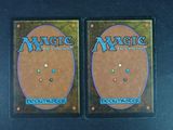 two decks of magic the gathering are shown on a black surface