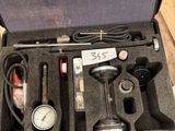 une mallette posée par terre, contenant des outils