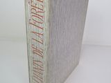 an old book with red writing on it sitting on a white surface