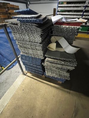 many stacks of fabric on a metal rack in a warehouse