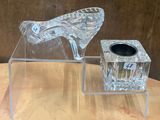 un vase en verre transparent et une paire de chaussures à talons hauts posés sur une table