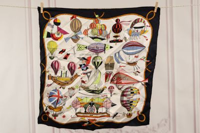 a scarf hanging on a clothes line with a picture of hot air balloons on it