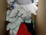 une boîte en carton remplie de vêtements pour bébé et de couches
