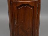 an antique wooden corner cabinet with marble top