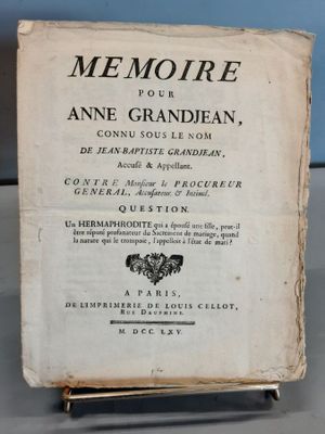 un vieux livre posé sur une table à côté d'un mur bleu