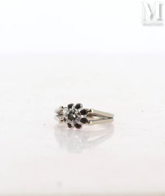 a close up of a ring with black and white diamonds on a white surface