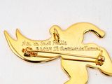 a gold plated brooch with a guitar on it