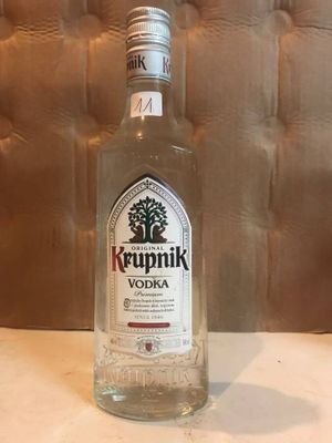 a bottle of krupnik vodka sitting on a table
