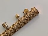 an image of a close up of a gold bracelet on a white surface