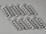 several pieces of silver metal are arranged on a white surface
