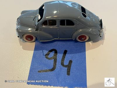 une petite voiture posée sur une feuille de papier bleue