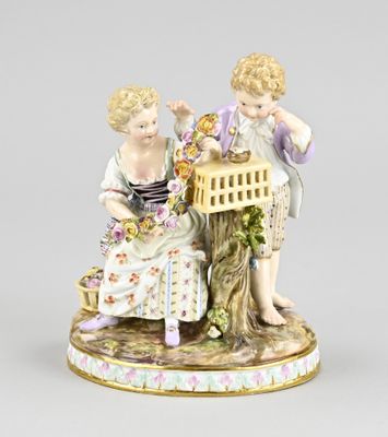 une figurine représentant deux enfants assis sur une souche d'arbre