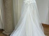 a wedding dress on a mannequin stand in a room