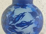 a blue glass vase with a blue fish design on it