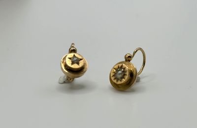 a pair of gold earrings with a star and moon on them