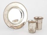 une assiette en argent et une tasse en argent placées l'une à côté de l'autre