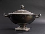 an antique silver bowl with a lid and handles on a black background