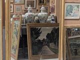 un grand miroir au milieu d'une pièce dont les murs sont ornés de tableaux
