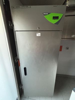 un réfrigérateur sur lequel est collé un autocollant vert, dans une cuisine