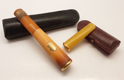 deux stylos et un étui en cuir posés sur une surface blanche
