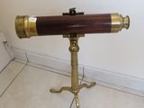 un télescope posé sur un trépied, sur un sol carrelé