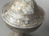 an image of a silver vase with a lid on a table