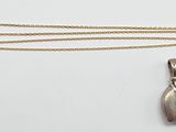 un pendentif en forme d'éléphant en argent, monté sur une chaîne en or