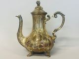 une théière en argent avec une anse sur une table