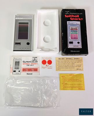 un petit appareil électronique posé sur une table à côté d'un colis