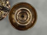 a small metal object on a table with a spoon