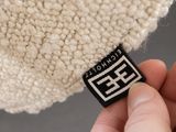 a close up of a person ' s hand holding a white knitted beanie