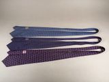 four ties are lined up in a row on a white surface