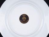 a white plate with a gold medallion on it