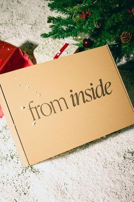 une pancarte en carton sur laquelle on peut lire « de l'intérieur », posée à côté d'un sapin de Noël