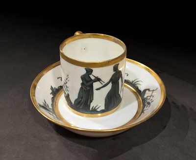 une tasse et une soucoupe ornées de l'image d'une femme