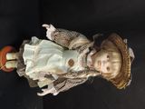 a doll that is wearing a hat and a dress