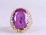 a close up of a ring with a purple stone in it