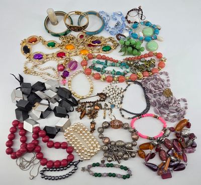 a pile of assorted necklaces and bracelets on a table