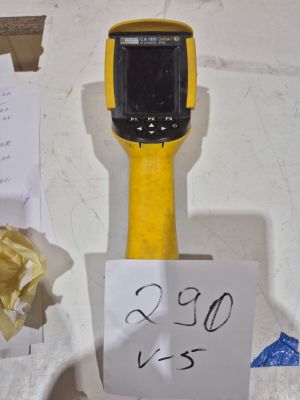 un objet jaune et noir posé sur une table, à côté d'une pancarte