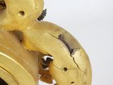 a gold clock that has a teddy bear on it
