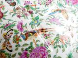 a close up of a plate with a bird and flowers on it