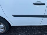 une petite voiture blanche garée dans un parking