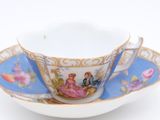 a cup and saucer with a picture of a couple on it